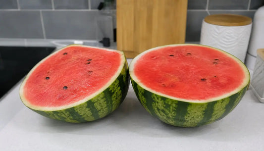 Cut in half watermelon on kitchen bench